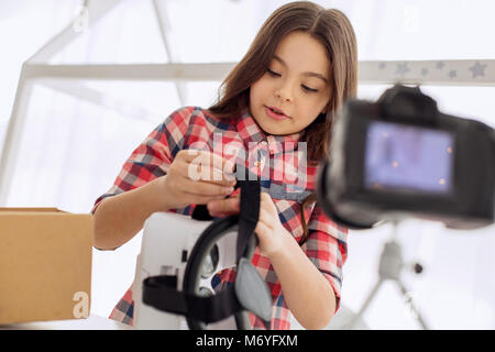 Ragazza allegra rivedendo VR auricolare nel suo vlog Foto Stock
