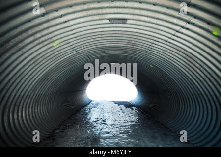 Acciaio ondulato corridoio con estremità incandescente e un terreno ghiacciato, industriale sfondo tunnel Foto Stock