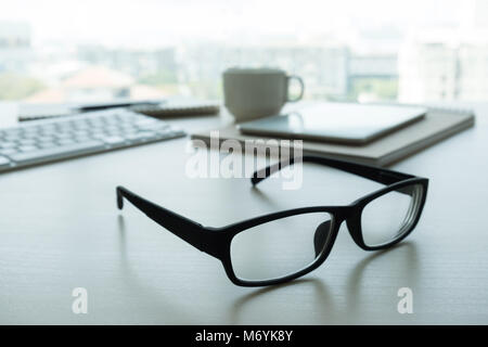 Close up di bicchieri e computer business sul posto di lavoro posto di lavoro in ufficio Foto Stock