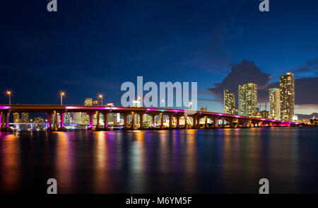 Vista della MacArthur Causeway bridge a Miami la notte sopra l'acqua. Foto Stock