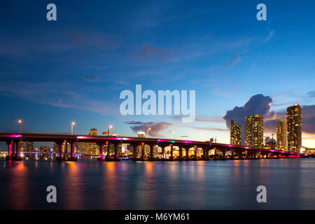 Vista della MacArthur Causeway bridge a Miami la notte sopra l'acqua. Foto Stock