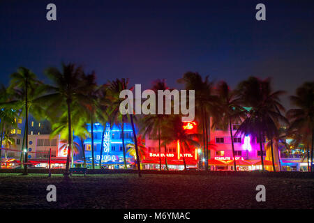 Ocean Drive a Miami la notte con vivaci colori di strada. Palme e alberghi in background. Vista dal South Beach. Foto Stock