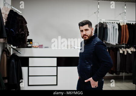 Elegante uomo turco presso il negozio di pellicce e giacche di pelle. Successo barba arabico l'uomo. Foto Stock