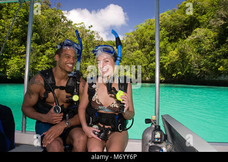 Divers (MR) in attrezzatura subacquea in procinto di entrare nell'acqua fuori da una barca in Le Rock Islands, Palau Micronesia. Foto Stock