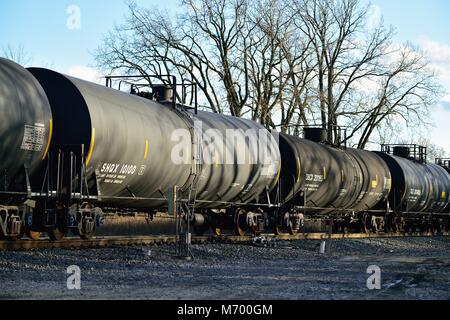 Bartlett, Illinois, Stati Uniti d'America. Una stringa di vetture del serbatoio all'interno di un treno merci che si muove attraverso un punto di trasferimento su Canadian National binari ferroviari. Foto Stock