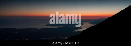 Sorprendente vista panoramica vista aerea dopo il tramonto sulla baia di Kotor con un cielo rosso dal parco nazionale di Lovcen Foto Stock