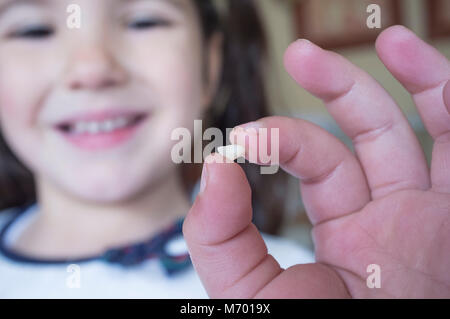 Poco più di 5 anni ragazza mostrando il suo primo bambino dente caduto fuori. Primo piano Foto Stock