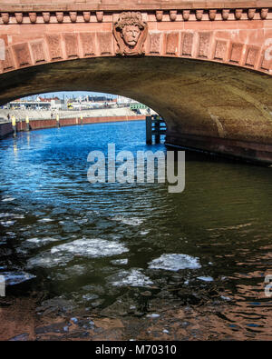 Berlino, Mitte. Moltkebrücke,Moltke Bridge. Rosso ponte in pietra arenaria con Von Blücher scultura testa congelati oltre il fiume Sprea, d'inverno. Foto Stock