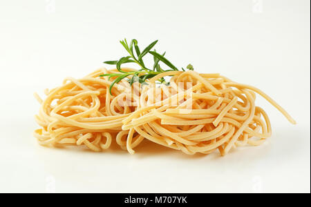 Fasci di non cotti gli spaghetti su sfondo bianco Foto Stock