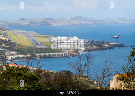 Un Boeing 737 rende la curva finale a terra alla notoriamente impegnativa l'aeroporto di Funchal in Madeira, Portogallo Foto Stock