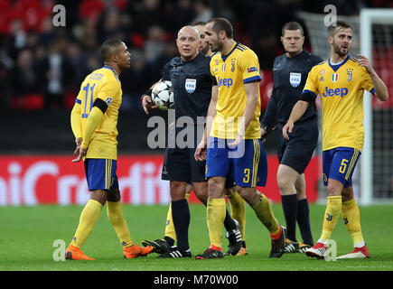 Giocatori Juventus arbitro surround Szymon Marciniak a metà tempo durante la UEFA Champions League round di 16, la seconda gamba corrispondono allo Stadio di Wembley, Londra. Foto Stock