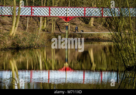 Bolton, Regno Unito. Il 7 marzo 2018. Un posto incantevole di sole dopo il freddo e umido clima degli ultimi giorni per le persone che usano il Queen's Park a Bolton, Lancashire. Un dog walker passa sotto Dobson ponte sopra il fiume Croal nel parco. Foto di Paolo Heyes, mercoledì 07 marzo, 2018. Credito: Paolo Heyes/Alamy Live News Foto Stock