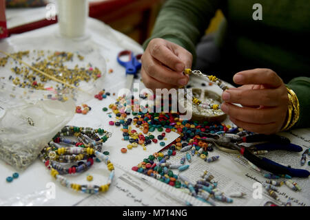 (180307) -- IL CAIRO, 7 marzo 2018 (Xinhua) -- Una donna egiziana rende un bracciale da materiali riciclati a un workshop in area di Moqattam del Cairo, Egitto, in data 7 marzo 2018. L'Associazione per la protezione dell'ambiente (APE) impostare il workshop come un reddito generare programma volto a potenziare le donne del Zabbaleen (garbage collector in arabo) comunità per migliorare la propria vita. Agendo come un hub di sicuro per una tale auto-racchiuso comunità, la scimmia ha lavorato per quasi tre decenni di offrire tanto bisogno di lavoro, la salute e l'istruzione cura di più di 70.000 residenti nella città di immondizia di Ca Foto Stock