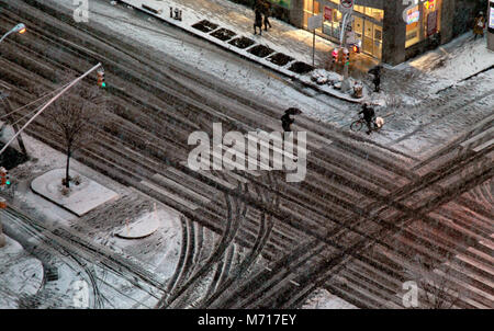 New York, Stati Uniti d'America. Marzo 7 .pedoni all'angolo con la 8th Avenue e la 24th Street nella sezione di Chelsea di Manhattan fanno la loro strada come una tempesta di neve ha colpito oggi previsto con accumuli di 6-10 cm di neve. Foto Stock