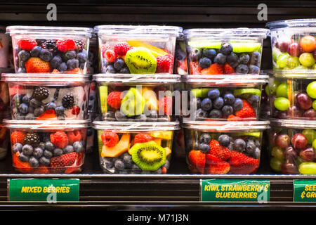 Supermercato negozio di generi alimentari espositore con frutta fresca in pezzi su scaffali in containe in plastica Foto Stock