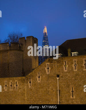 Il coccio e la Torre di Londra con la Shard dietro la Torre di Londra nella distanza di notte. Foto Stock