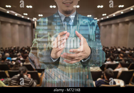 La doppia esposizione di imprenditore battimani e sorridente al di sopra del grafico di trading su un astratto foto sfocata della sala conferenze o sala seminario con altoparlanti Foto Stock