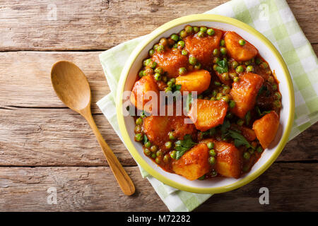 Indiano Vegetariano, Aloo Matar realizzato da patate, piselli verdi, erbe e salsa piccante closeup su una piastra superiore orizzontale vista da sopra Foto Stock