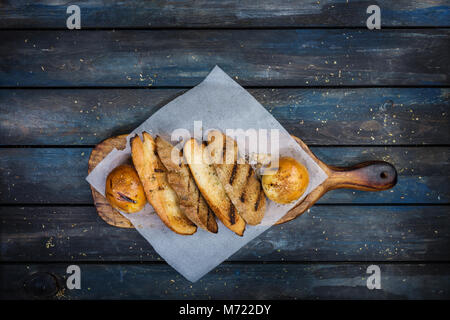Grigliata di pane tostato sul tagliere. Foto Stock