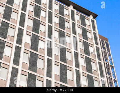 Un vecchio hotel con un sacco di finestre, piccioni seduto sul davanzale. Vista dal basso. Foto Stock