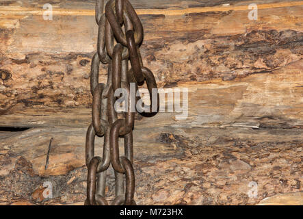 Catena isolata su uno sfondo di legno Foto Stock