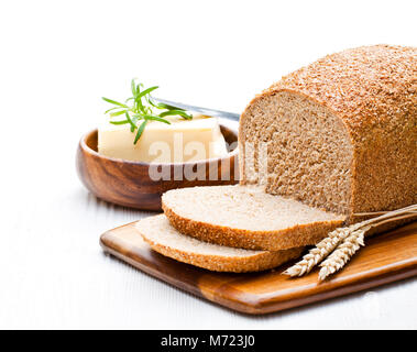 Fette di slow-biologico cotto al pane integrale con burro e rosmarino e spighe di grano Foto Stock