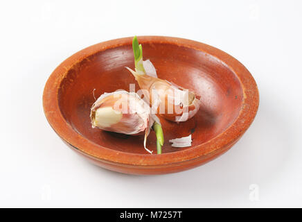 I chiodi di garofano di aglio fresco nel recipiente di terracotta Foto Stock
