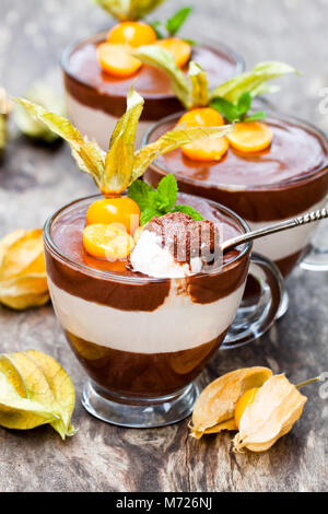 Layered dessert con physalis sul tavolo di legno Foto Stock