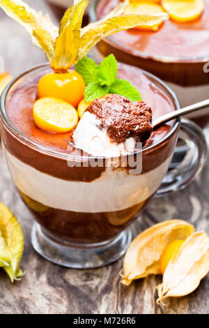 Layered dessert con physalis sul tavolo di legno Foto Stock