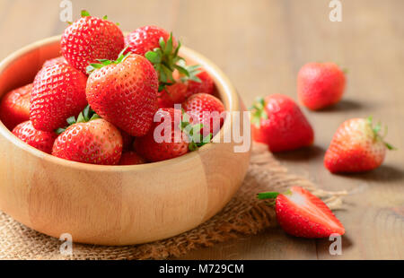 Carni rosse bacche Fragole in ciotola di legno su uno sfondo di legno vecchio, dieta frutta concept Foto Stock