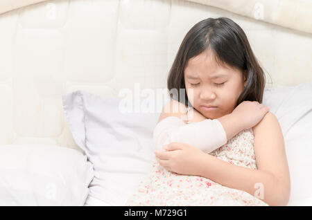 Bambina con la sua danneggiato il braccio destro in gesso colato e bendaggio elastico, il concetto di salute Foto Stock