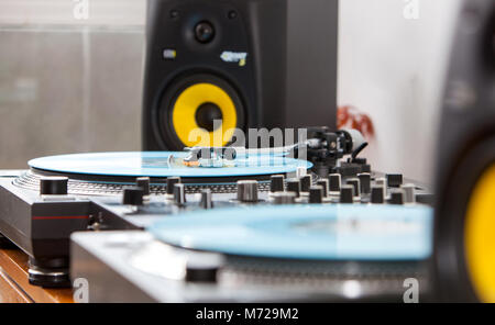 Un dettaglio sul DJ set-up con due giradischi, mixer e monitor altoparlante. Tutti impostati su legno tavolo ripiegato. Foto Stock