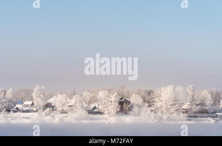 Paesaggio invernale, bianca coperta di neve su alberi e case locali nel paesaggio urbano, in Russia Foto Stock