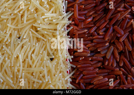 Vermicelli di pasta o di maccheroni con marrone riso integrale di sfondo texture cibo tradizionale italiano il concetto di alimentazione corretta e sana lifesty Foto Stock