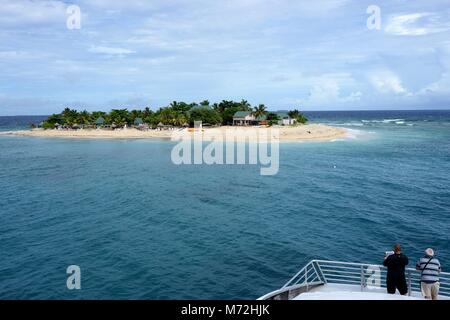 Una barca turistica si avvicina Castaway Island in una giornata di sole. L'isola è molto vicino alle principali città di Nadi nelle isole Figi. Questo lo rende un luogo molto popolare per una gita di un giorno. Altre isole sono molto più lontani. Questa isola ha un buon bar e ristorante. Foto Stock