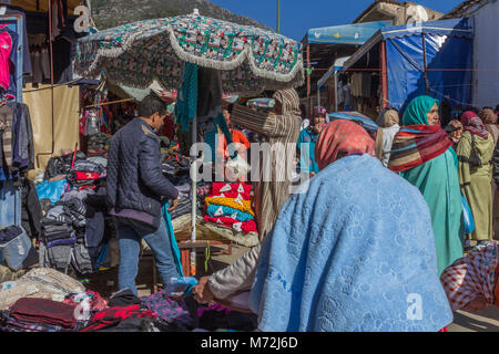 Una trafficata strada vibrante scena mostrando la popolazione locale al mercato regolare sul giorno di mercato a Chefchaouen, Marocco Foto Stock