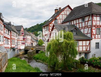 Pittoresco borgo Monreal con metà case con travi di legno lungo creek Eltzbach in Eifel, distretto Mayen-Koblenz Renania-Palatinato, Germania occidentale Foto Stock