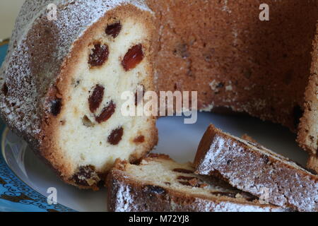 Pan di Spagna con uvetta con crosta dorata spolverato con zucchero a velo vicino a Foto Stock