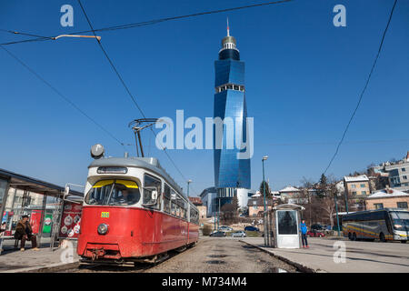 SARAJEVO, BOSNIA - Febbraio 16, 2018: Tram pronti per la partenza per la stazione ferroviaria di arresto, la torsione Avaz Tower è visto in background. La torre è Foto Stock