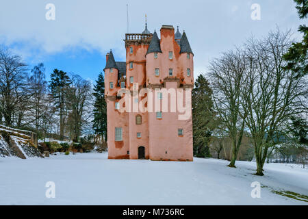 Castello di Craigievar ABERDEENSHIRE in Scozia con la torre rosa circondato da neve invernale alberi sfrondato e un piccolo giardino Foto Stock