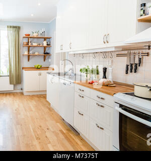 Cucina interna con tulipani rossi in vaso sul tavolo della cucina Foto Stock