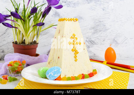 Cagliata tradizionale torta di Pasqua con frutta candita e fiori di primavera crocus sulla vacanza sfondo luminoso. Pasqua cottage cheese dessert. Pasqua fest Foto Stock