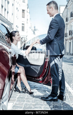 Bella donna felice di uscire dalla macchina Foto Stock