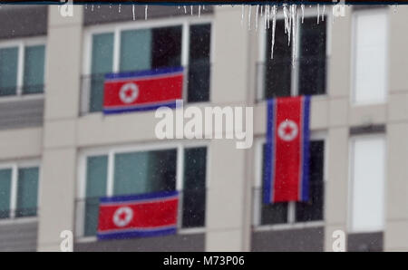 Pyeongchang, Corea del Sud. 08 marzo 2018, Paralimpiadi. Atleta del villaggio. Corea del Nord le bandiere appese sotto ghiaccioli dalle finestre di alla Corea del Nord la delegazione di alloggio. Foto: Karl-Josef Hildenbrand/dpa Credito: dpa picture alliance/Alamy Live News Foto Stock