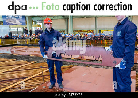 13 febbraio 2018, Germania, Wismar: gli apprendisti Martin Haecker (L-R) e Erik Merck titolari di una pensione di acciaio sulla macchina di taglio con il profilo del futuro sistema mondiale di nave da crociera su di esso. La partenza ufficiale per circa un miliardo di euro più costoso, 340 metri più a lungo e 20 ponti della nave maggiore è celebrato. Foto: Jens Büttner/dpa Foto Stock