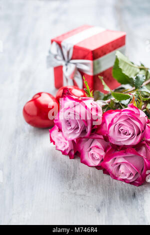 Le rose. Le rose rosa con due cuori e regalo rossa. Foto Stock