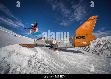 Snowboard jump al disopra del piano in snowpark montagne invernali nelle Alpi Italiane Foto Stock