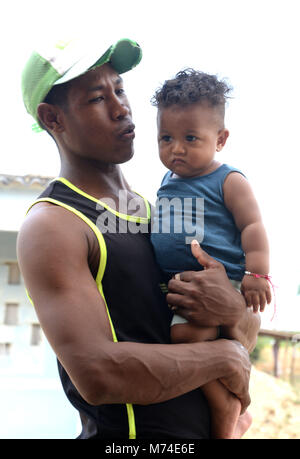 Un orgoglioso sorridente nuovo papà tiene il suo Chubby podgy figlio. Foto Stock