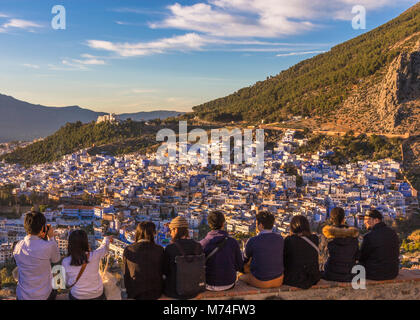 Una fila di turisti guardare il tramonto sopra i tetti di Chefchaouen dalla moschea spagnola, a nord-ovest del Marocco. Foto Stock