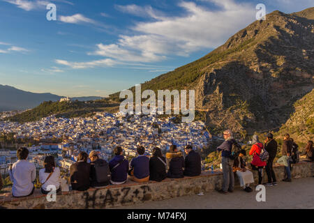 Una fila di turisti guardare il tramonto sopra i tetti di Chefchaouen dalla moschea spagnola, a nord-ovest del Marocco. Foto Stock